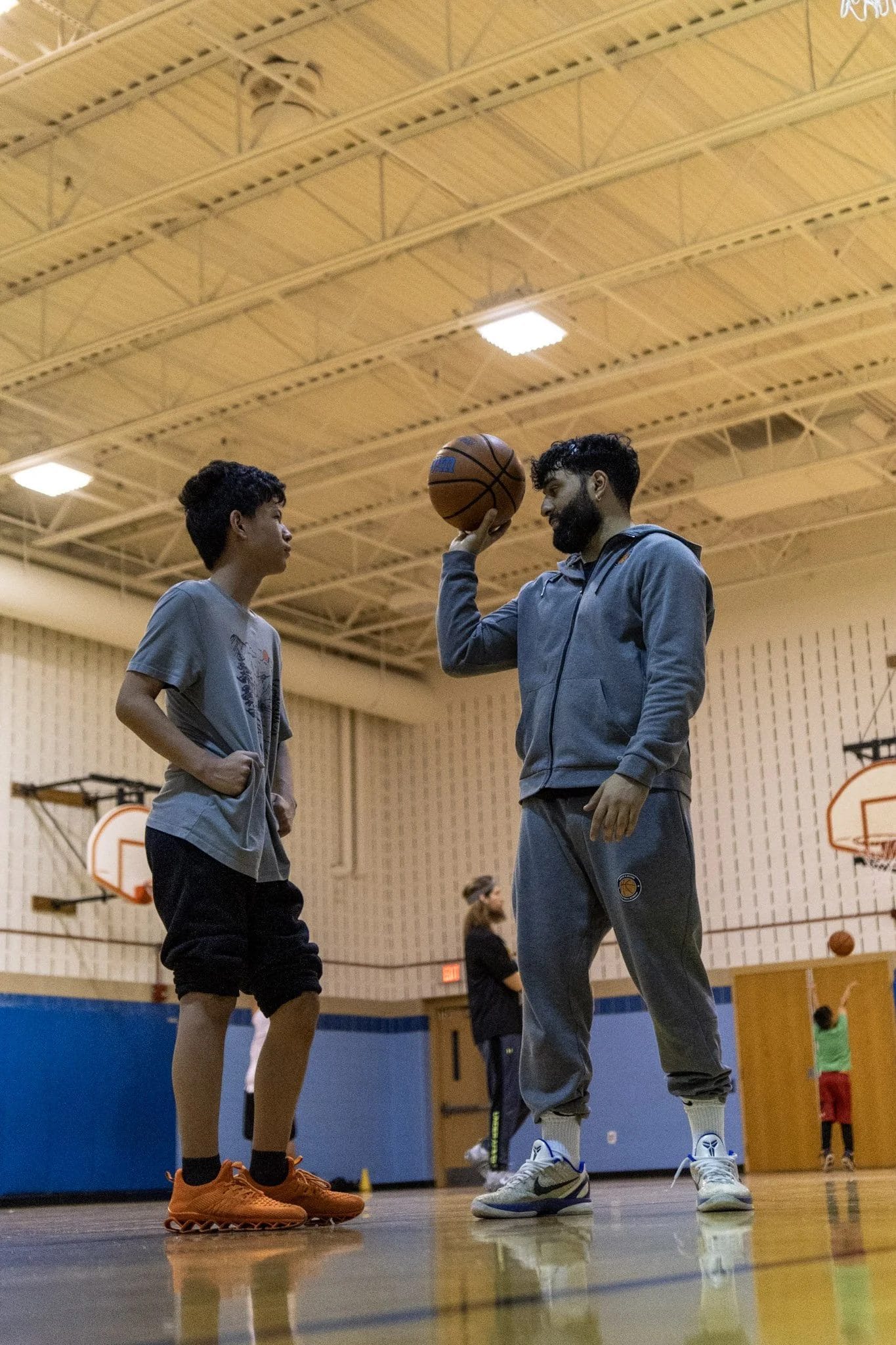 Coach Anthony working through a shooting form drill with an athlete in the gym